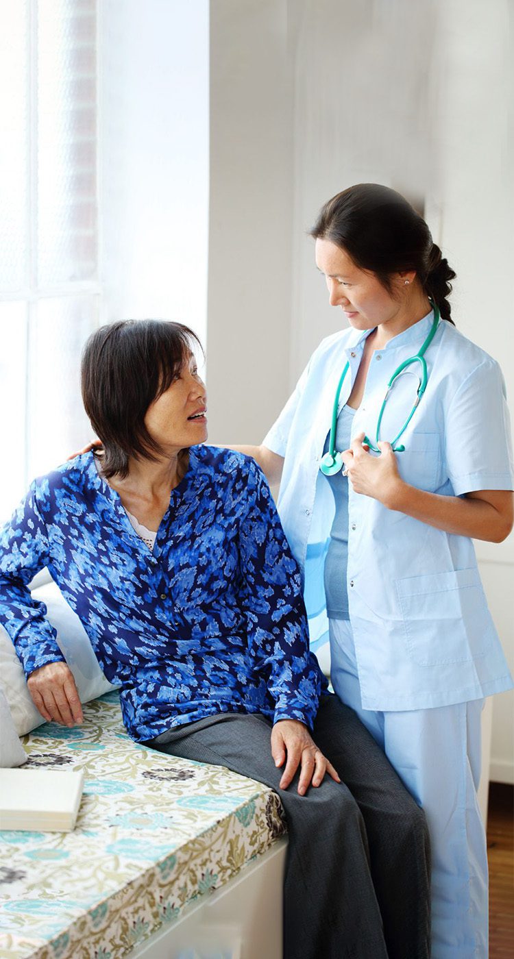 Nurse with stethoscope consulting seated patient