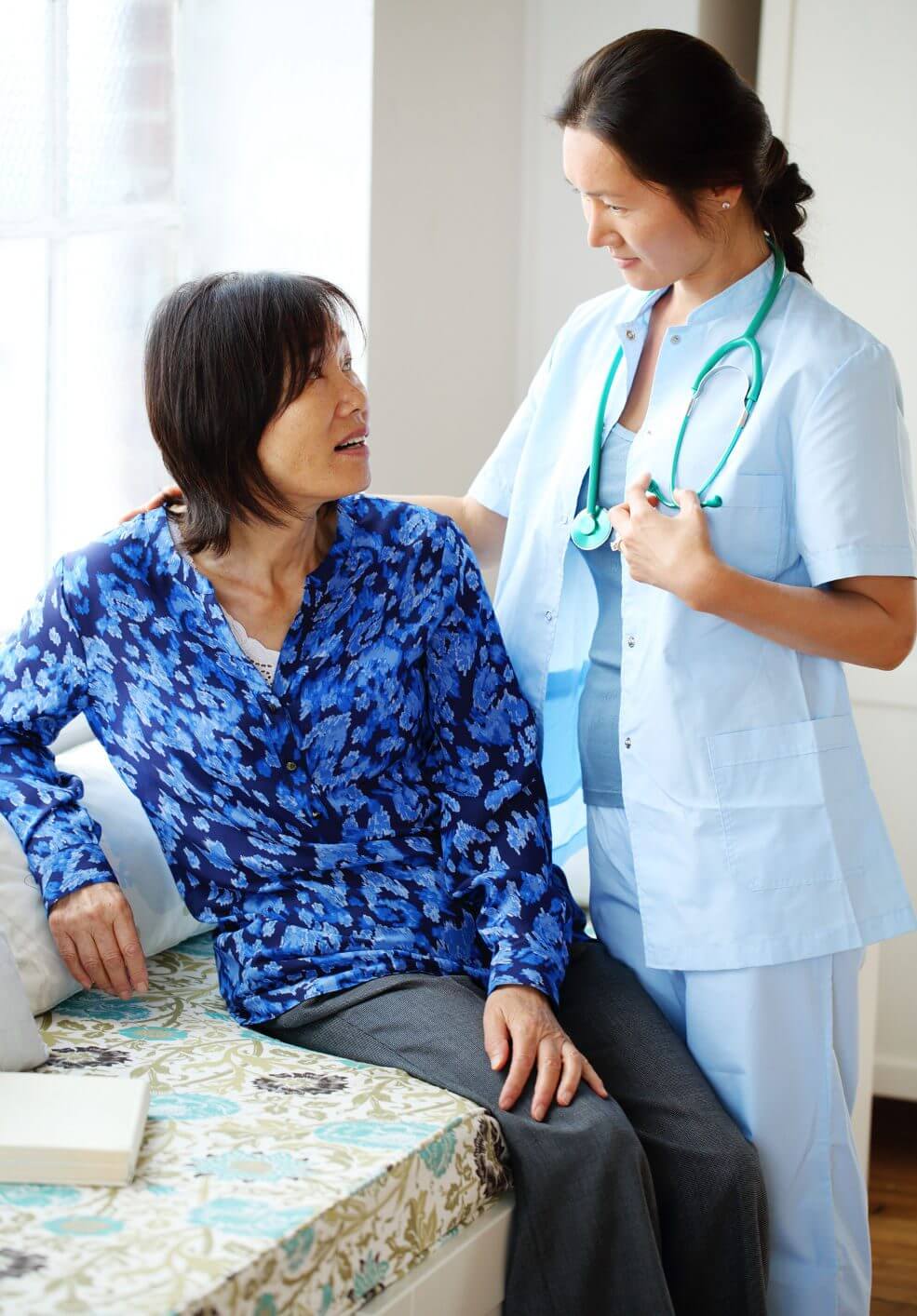 Nurse comforting a patient in a medical setting.